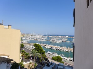 Un puerto deportivo con numerosas embarcaciones amarradas, rodeado de edificios y un cielo despejado.
