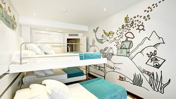 Une chambre avec des lits superposés, dont un mur est décoré d’une fresque représentant une sirène et un paysage sous-marin.