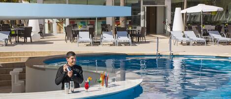 A poolside area with lounge chairs and a bar.