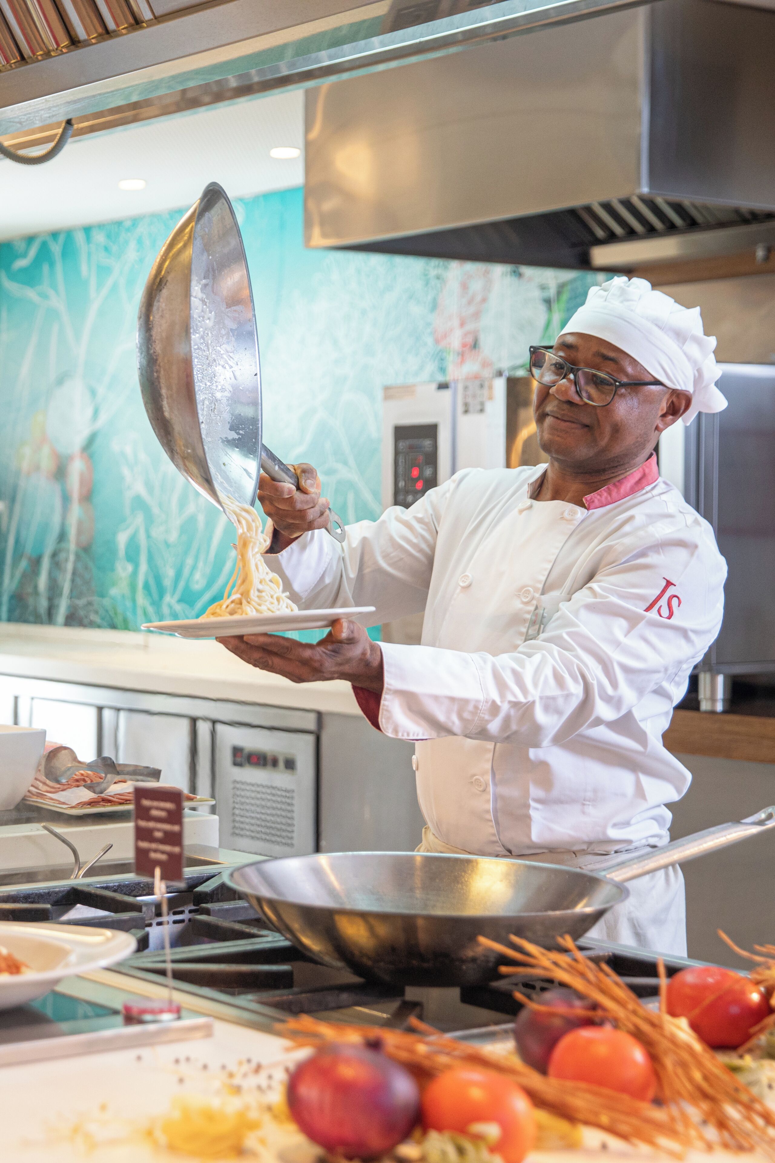 Un chef en un ambiente de cocina profesional, usando uniforme y gorro de chef, con atención a la preparación de alimentos.