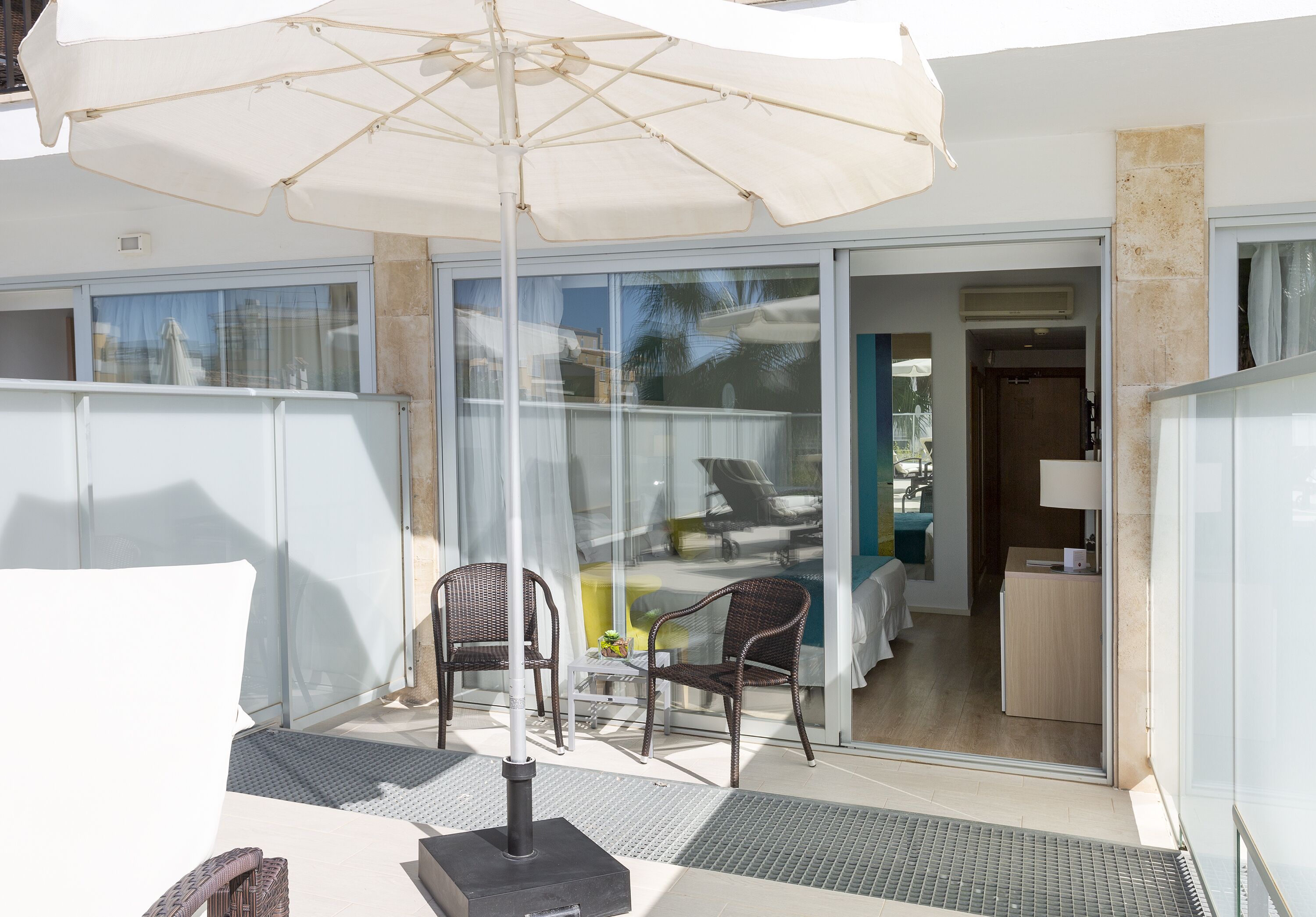 Un espace extérieur aménagé avec une table, des chaises et un grand parasol.