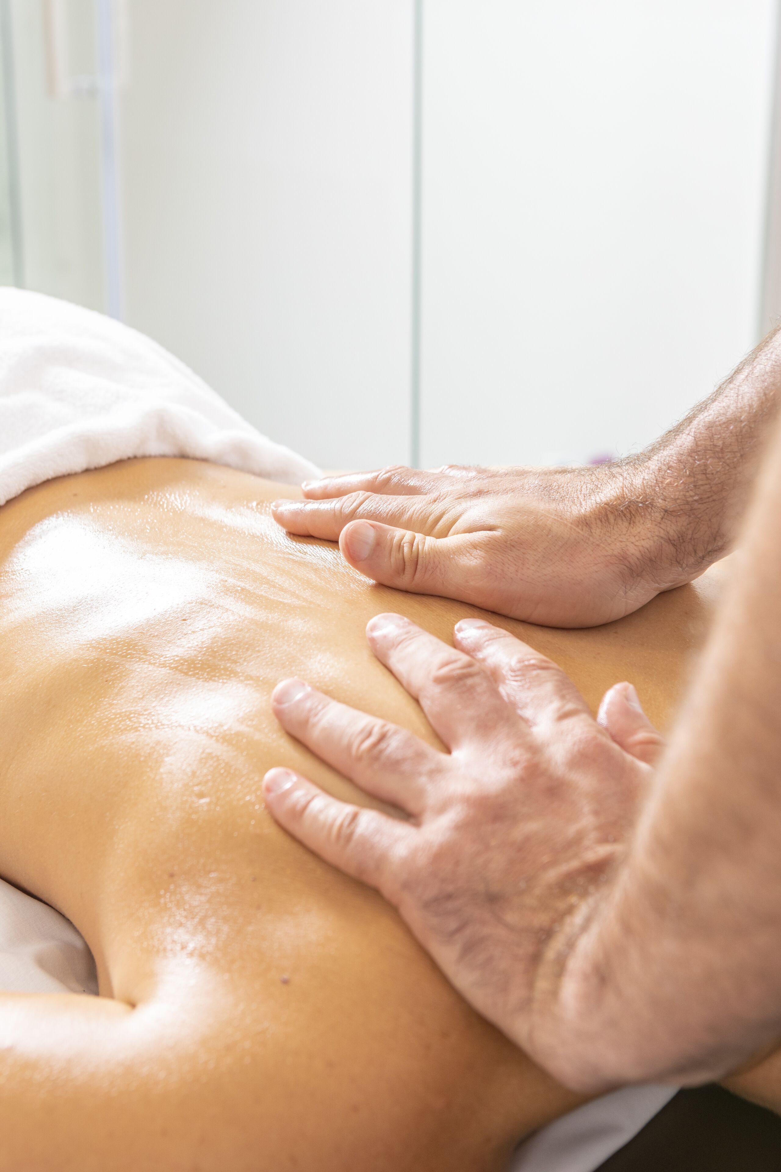 A close-up of hands performing a massage on a person's back.