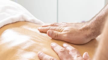 A close-up of hands performing a massage on a person's back.
