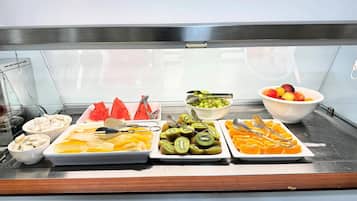 A buffet with various fruits and vegetables, including watermelon, kiwi, and oranges.