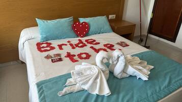 Ein Hotelzimmer mit einem Bett, das mit einer 'Bride to be!'-Dekoration, einem Holzkopfstück, einem Nachttisch und einem Besen ausgestattet ist.
