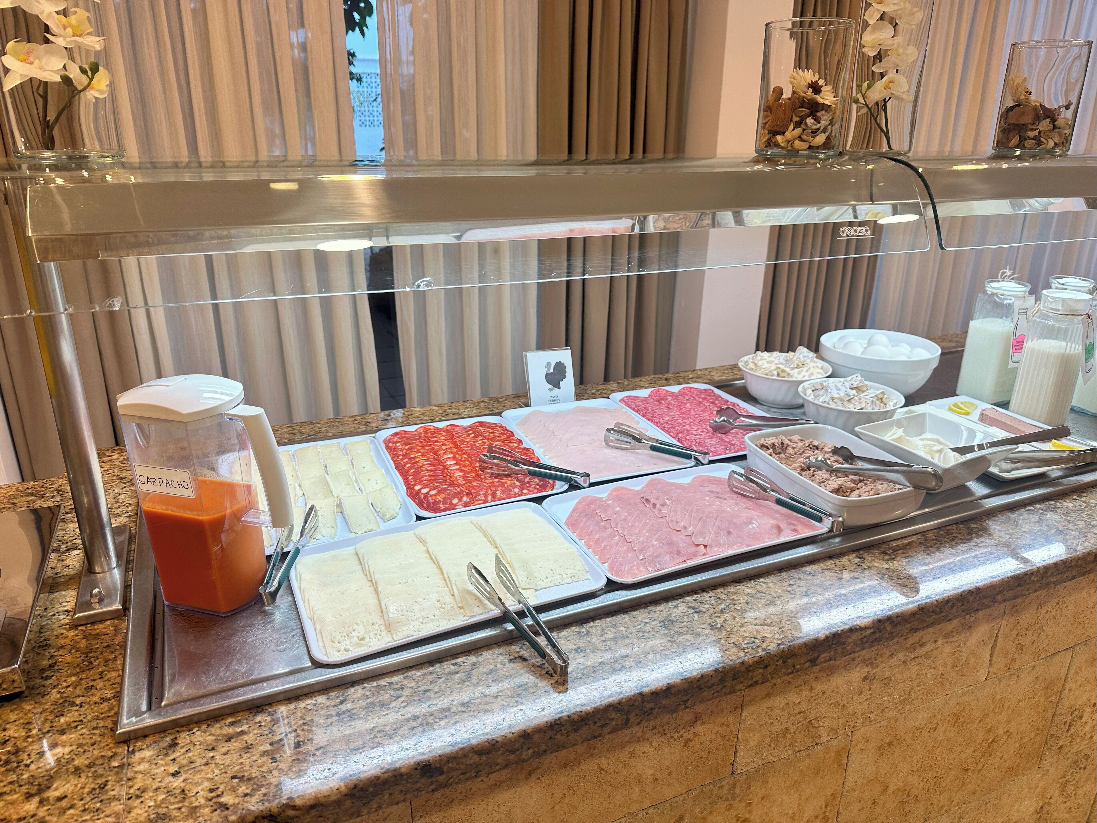 A buffet with various food items and a blender labeled "GAS PACHO".