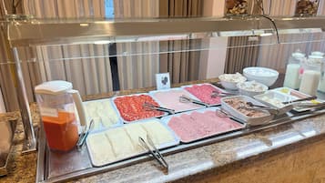 A buffet with various food items and a blender labeled "GAS PACHO".