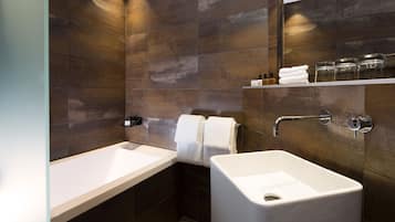 Un baño moderno con bañera, lavamanos y espejo.