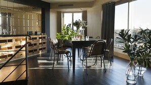 A modern dining area with a large table, chairs, and potted plants. - Hôtel Le Chat Noir (Paris)