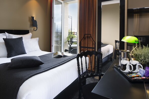A hotel room with a bed, a chair, a table with a tray of items, and a view of the outdoors. - Hôtel Le Chat Noir (Paris)