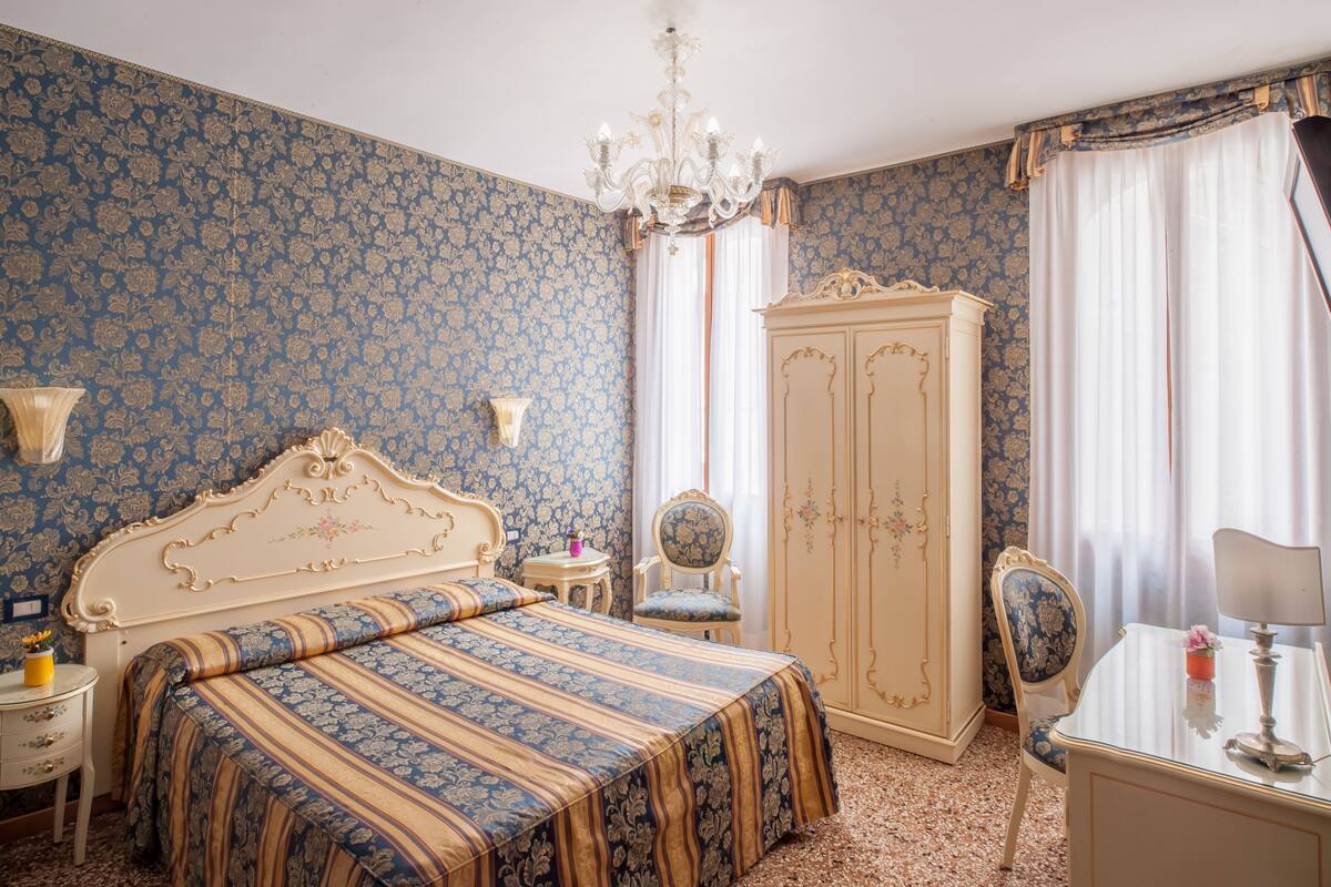 Une chambre à coucher avec un grand lit, une armoire, un bureau et une chaise.