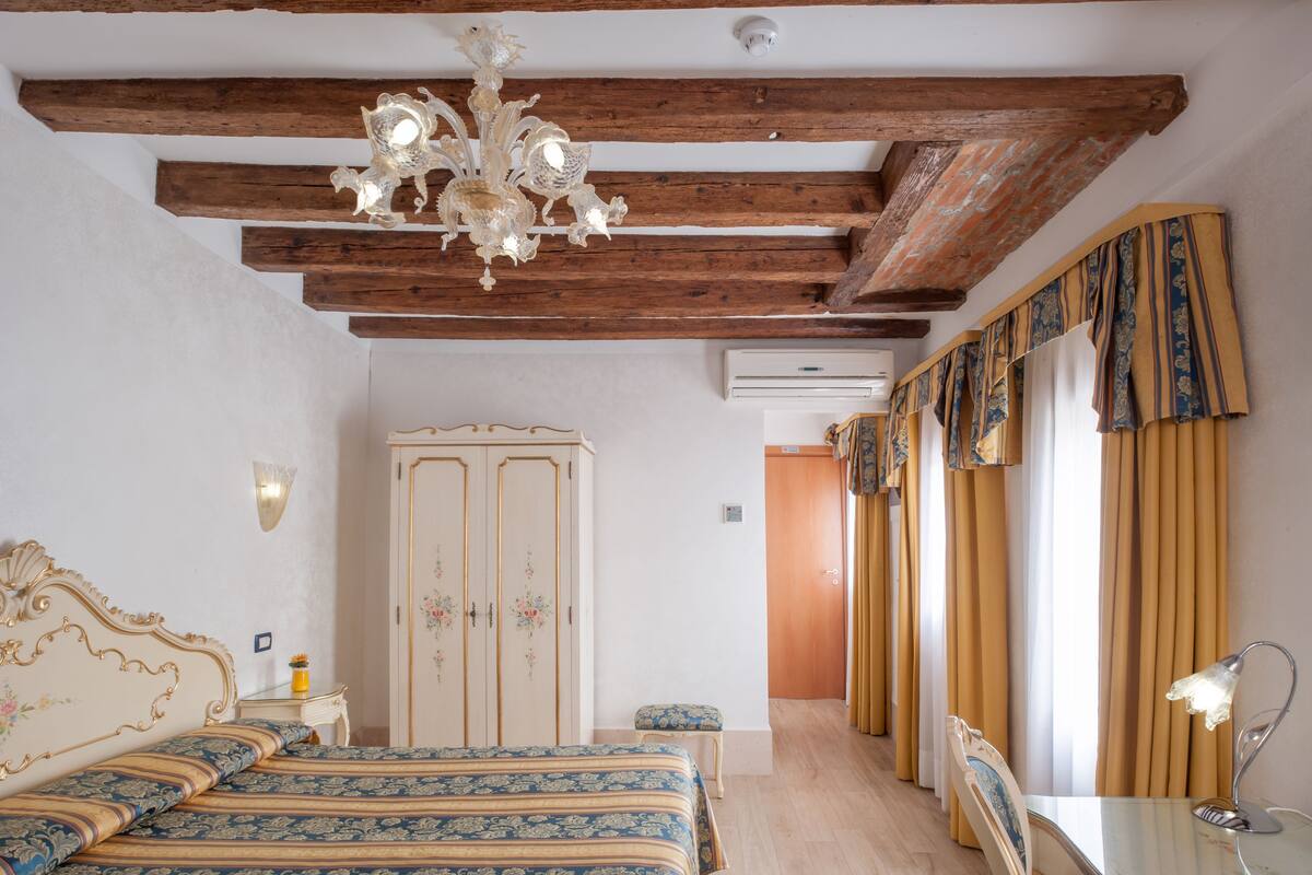 Une chambre à coucher avec un lit, une armoire, un bureau et un lustre.