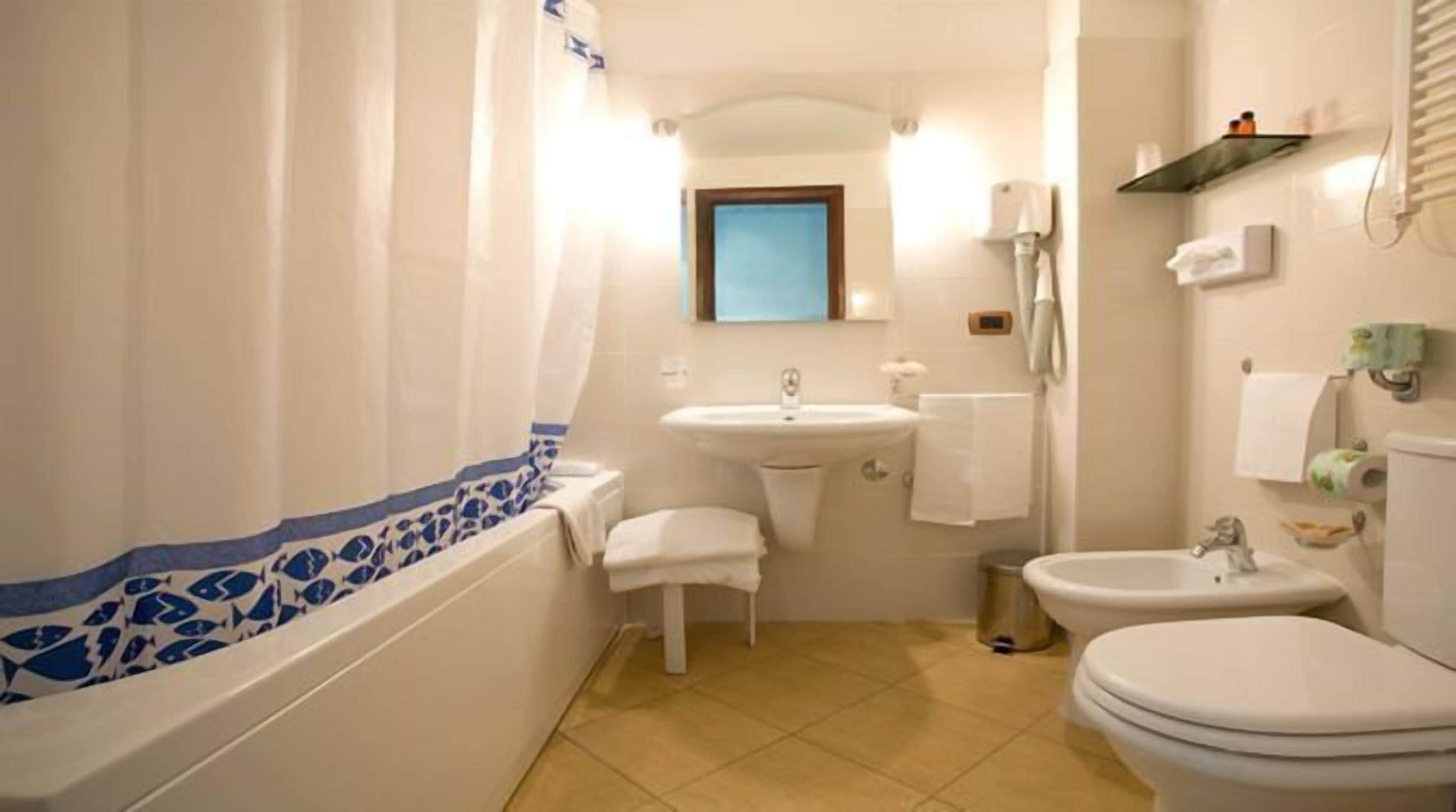 A bathroom with a bathtub, a sink, a toilet, and a shower.