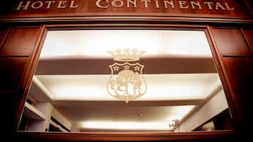 Un letrero de hotel con el nombre 'HOTEL CONTINENTAL' y un emblema de escudo.