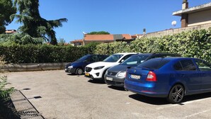 Un estacionamiento con varios coches aparcados en fila.