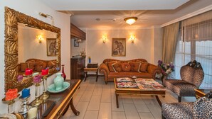 A living room with a sofa, armchairs, a coffee table, a fireplace, and a large mirror. - Hotel Daphne - Special Class (Istanbul)