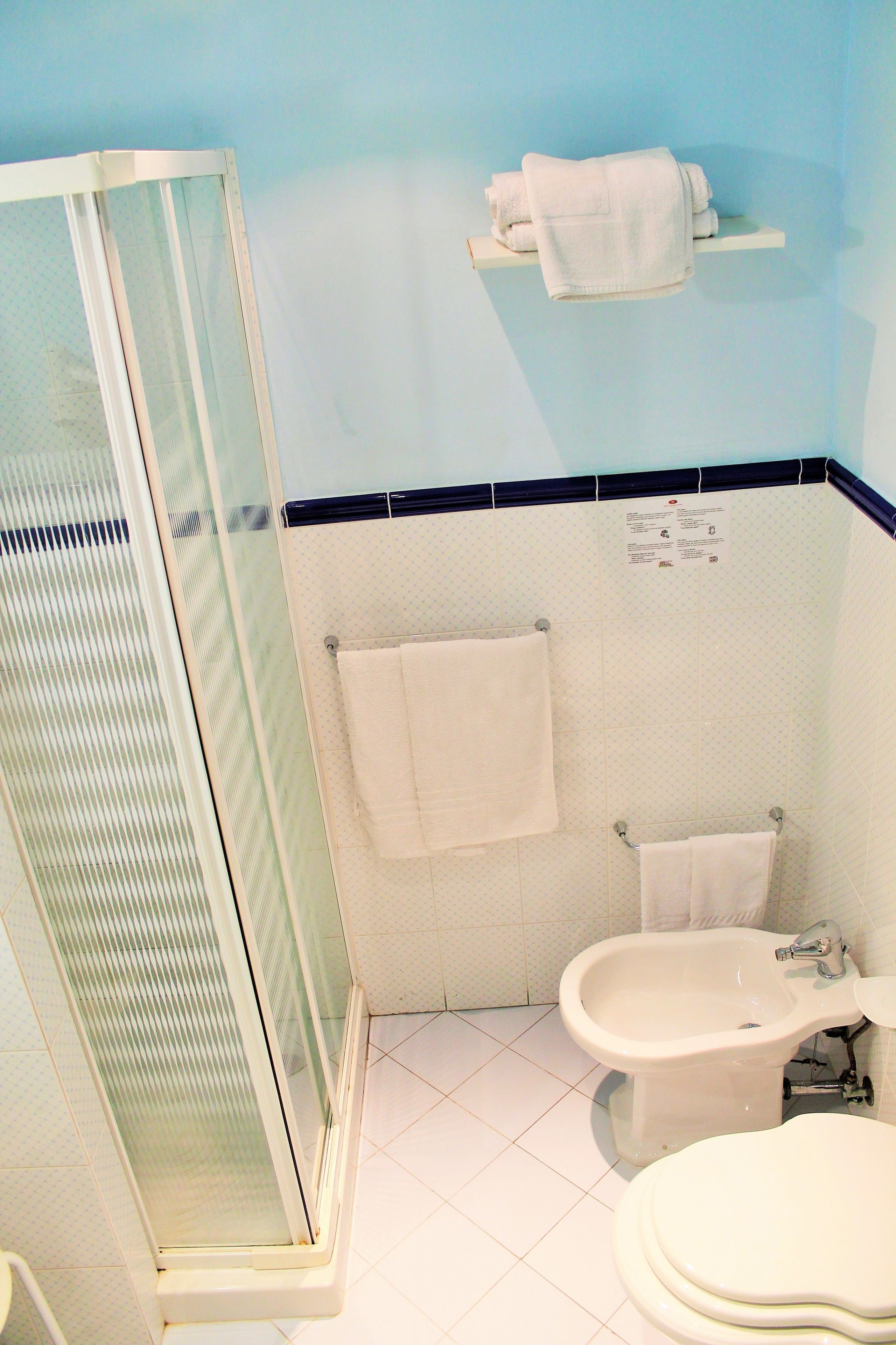 Un baño con ducha de vidrio, un bidé y un inodoro.
