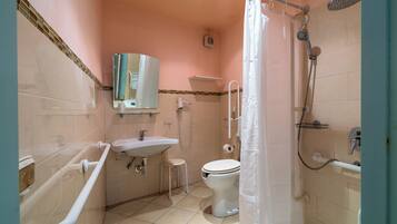 Bagno con servizi igienici, lavandino, doccia e maniglione.