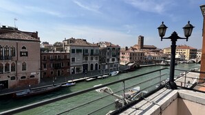 Ein Kanal mit Booten, historischen Gebäuden und blauem Himmel.