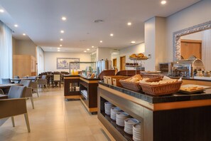 A modern breakfast area with a buffet setup, including bread baskets and a coffee station. - TRYP by Wyndham Porto Centro Hotel (Porto)