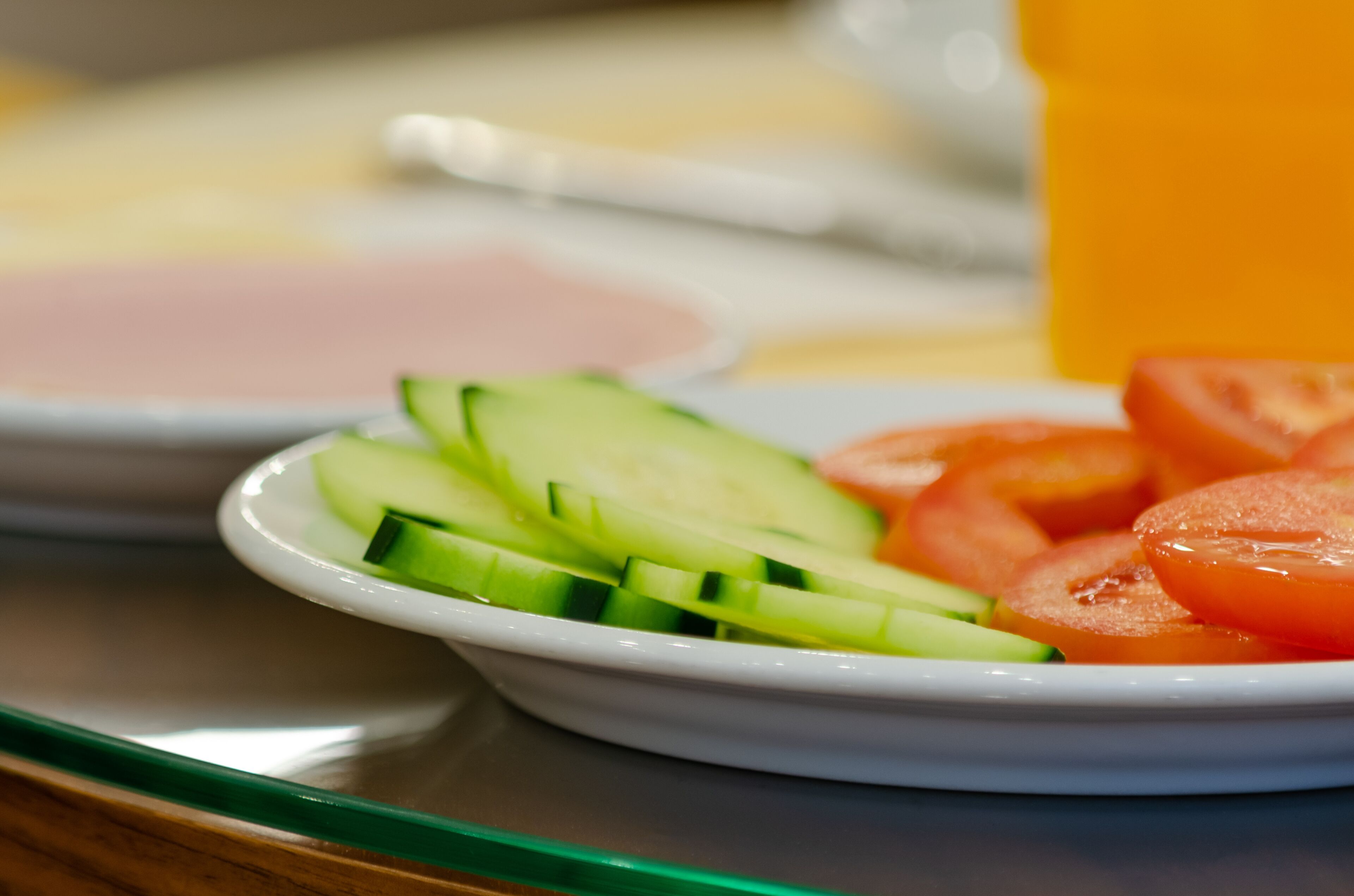 Un plato con rodajas de pepino y tomate sobre una bandeja.