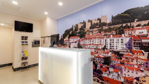 Un mostrador de recepción con un mural de la ciudad al fondo.