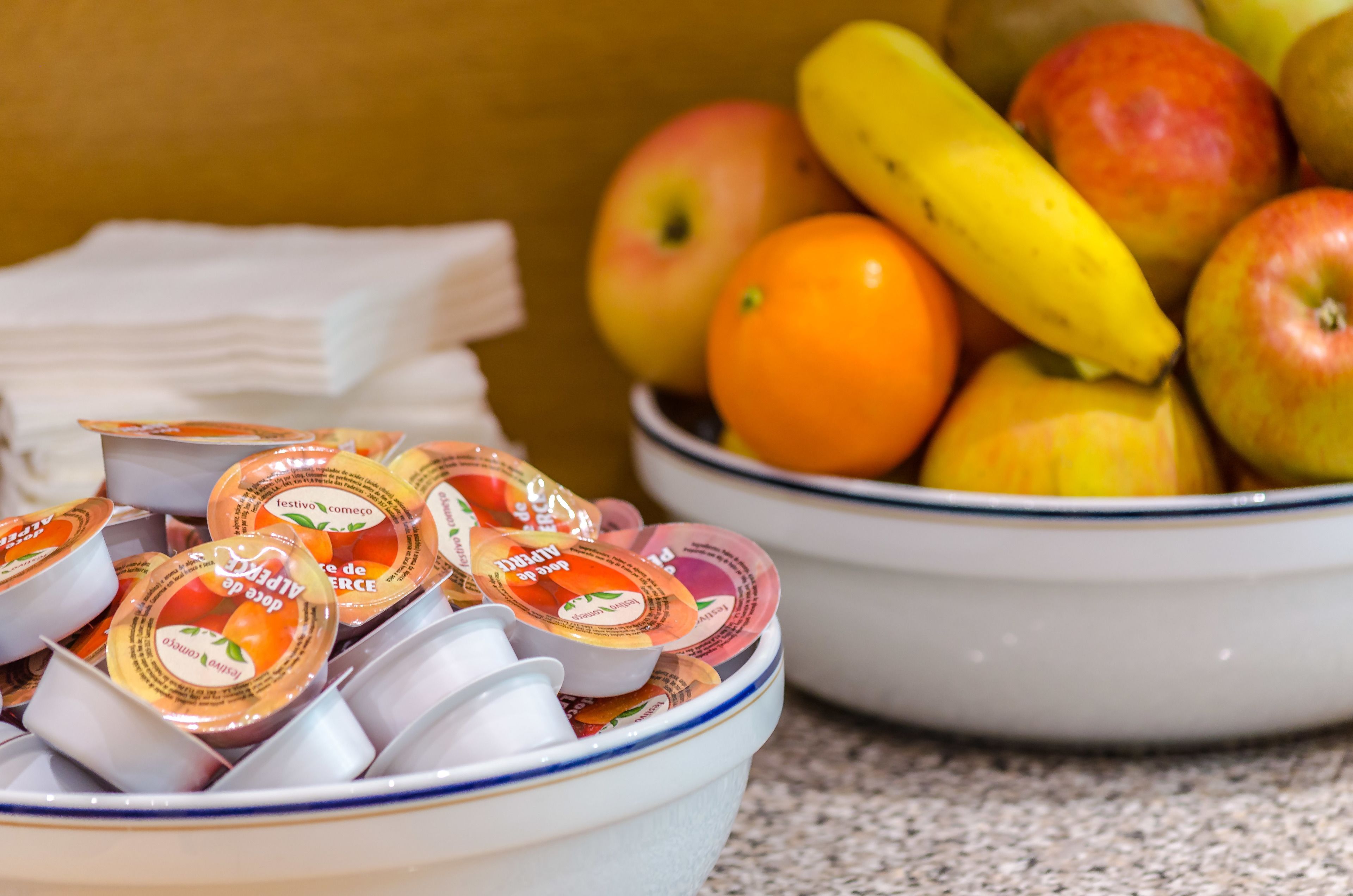 Un tazón de vasitos de yogur y un tazón de frutas.