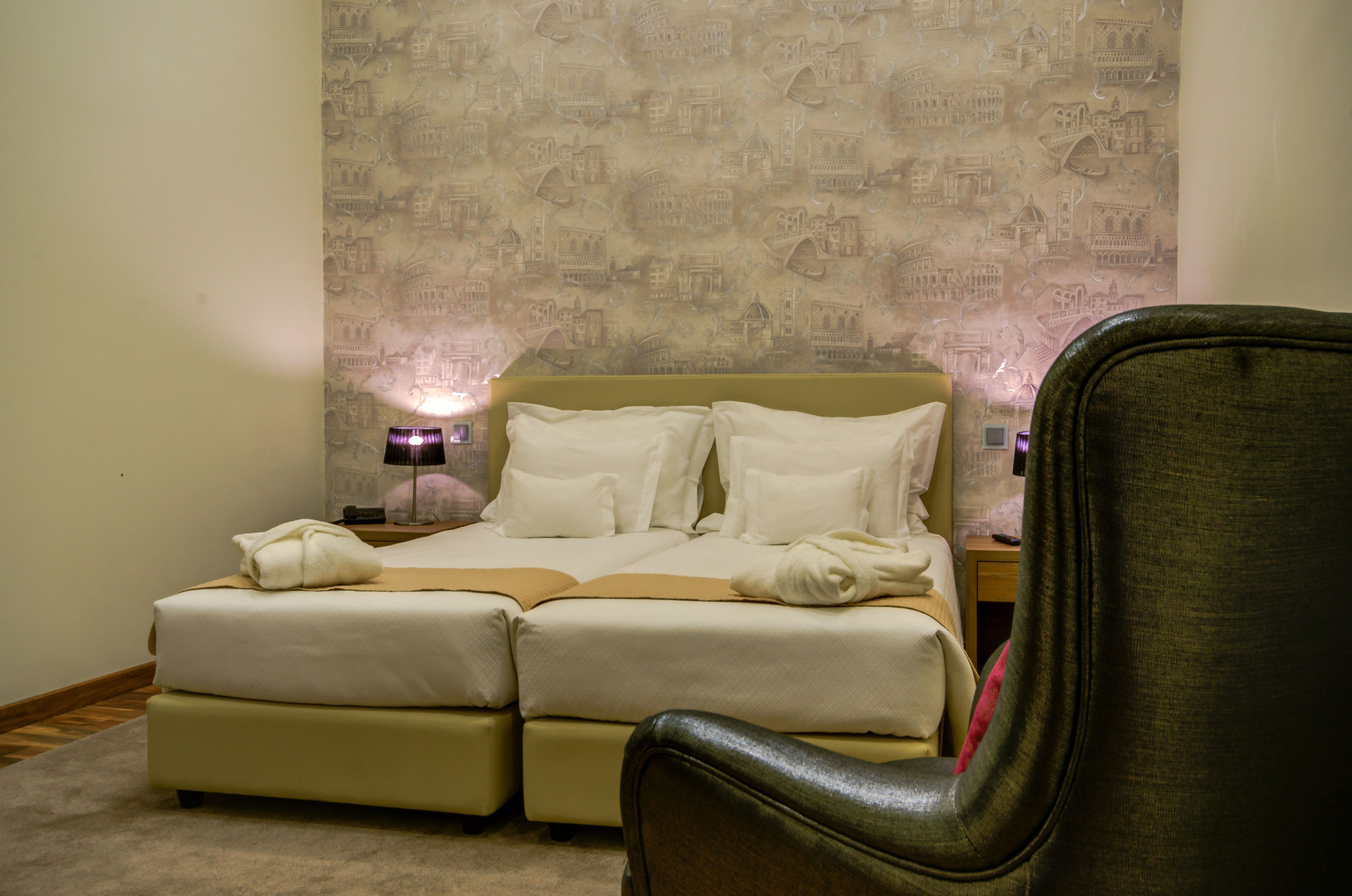 Un dormitorio con cama doble, una mesita de noche, una lámpara y una silla.