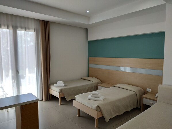Una habitación de hotel con dos camas individuales, un escritorio y una silla.