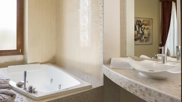 Un baño moderno con una bañera grande, un lavabo y un espejo.