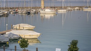 A marina with boats docked, a lighthouse, and a paved walkway with benches. - Hotel Mayer & Splendid – Wellness e Spa (Desenzano del Garda)