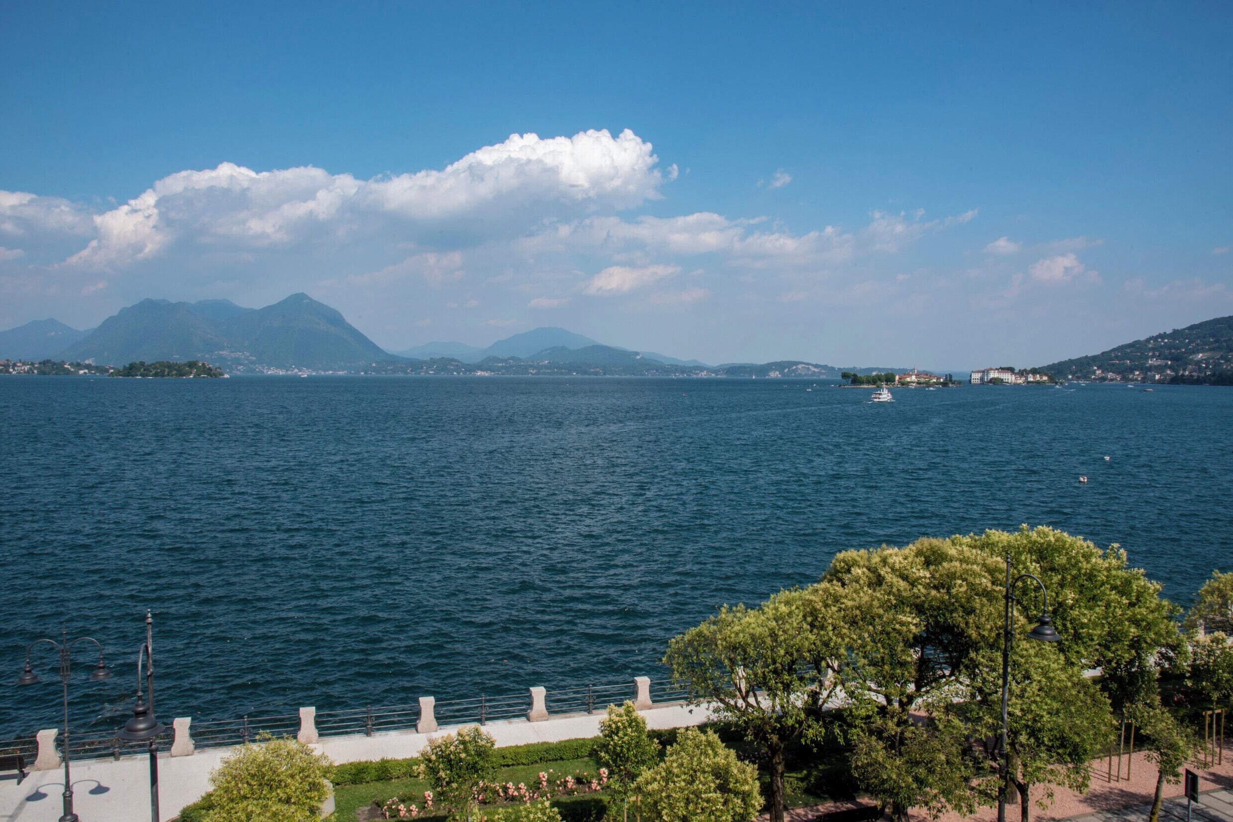 Une vue sur le bord de l’eau, avec un ciel dégagé, une eau calme et des montagnes à l’horizon.