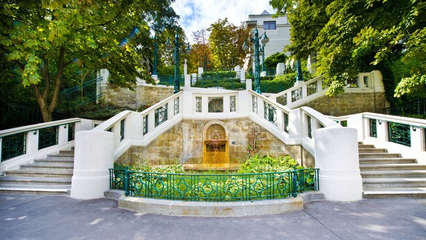 A stone staircase with a fountain at the center, surrounded by a green metal railing and white balustrades. - Hotel Strudlhof (Vienna)
