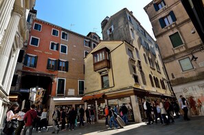 A busy street with a hotel named "HOTEL ORION" and a variety of shops and buildings. - Hotel Orion (Venice)
