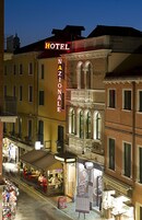 Un hotel llamado "Nazionale" con un cartel llamativo, tiendas adyacentes y vista a la calle.