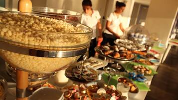 A buffet with various food items and a large bowl of nuts.