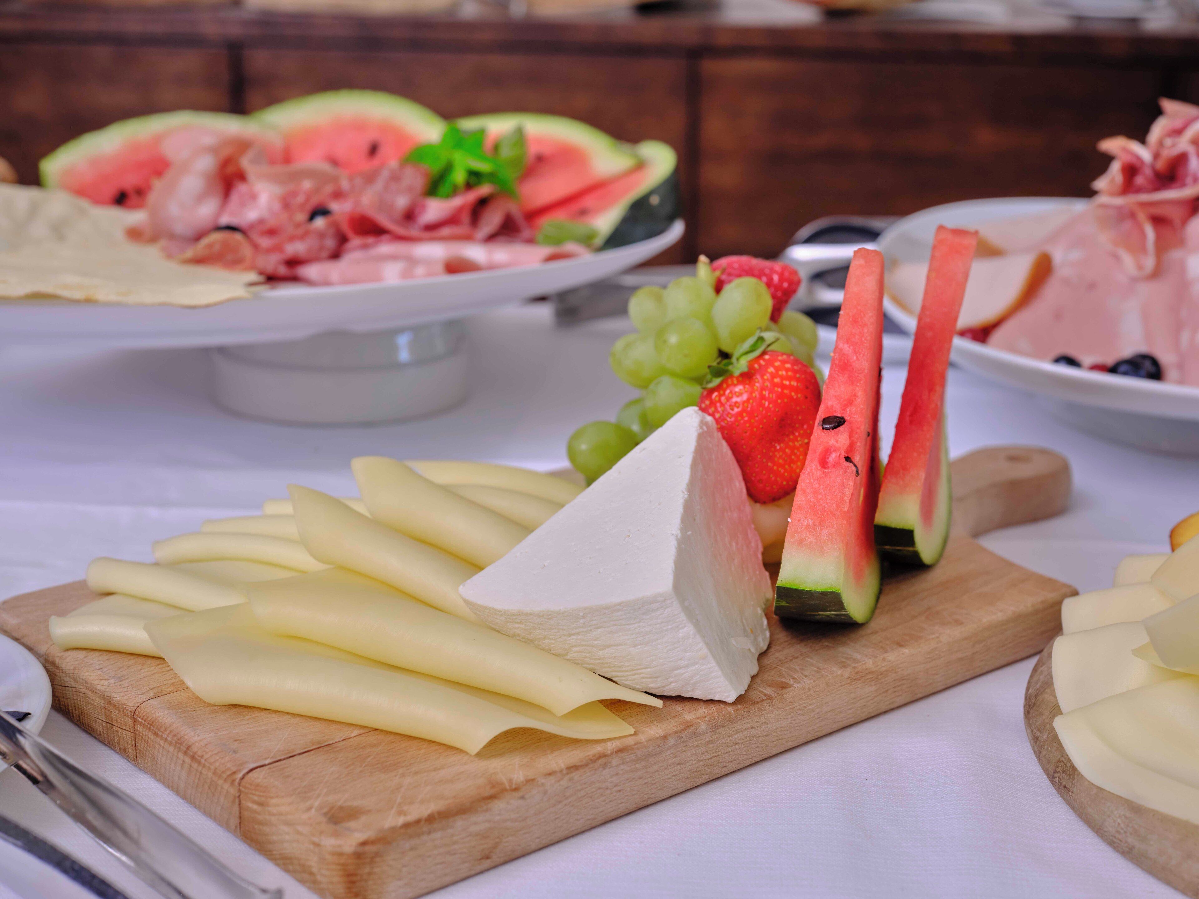 Una tabla de quesos con diversos quesos y frutas.