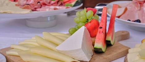 Una tabla de quesos con diversos quesos y frutas.