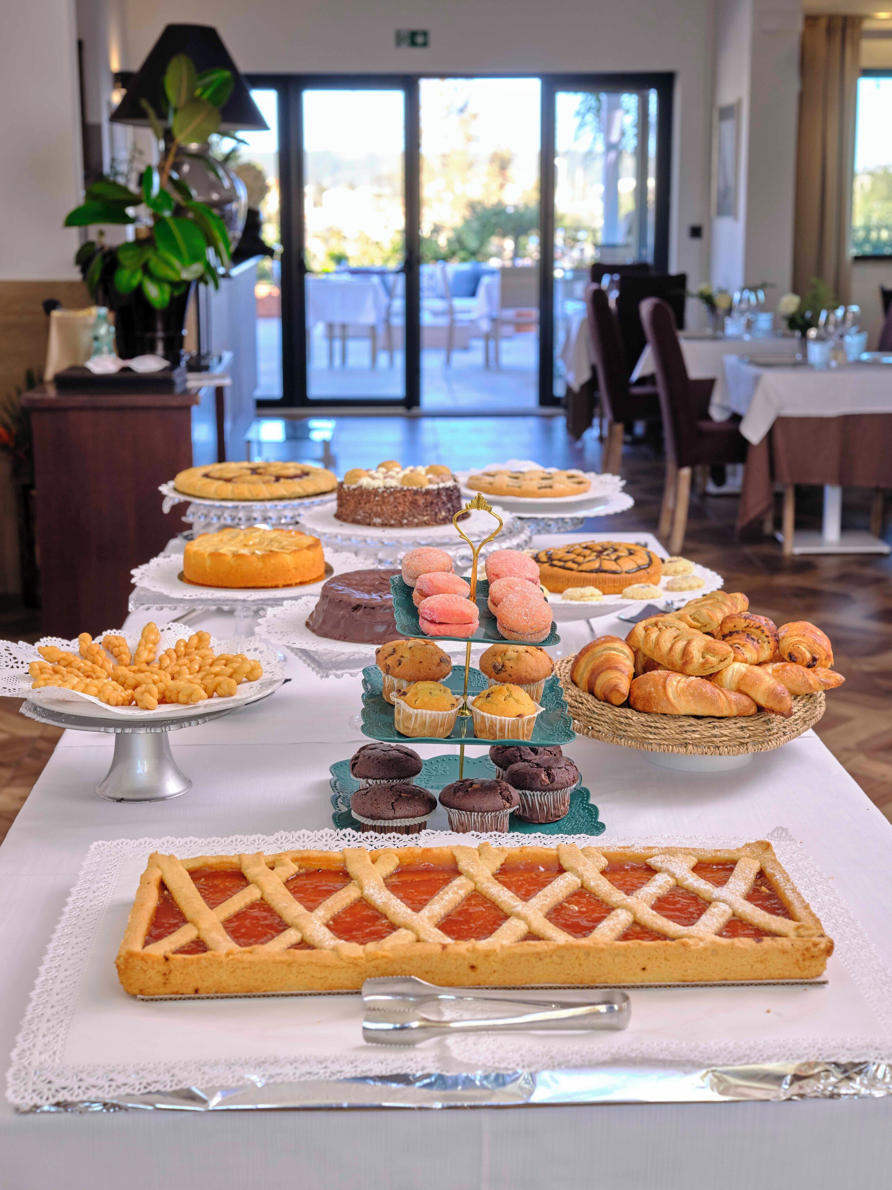 A buffet table with various desserts and pastries.
