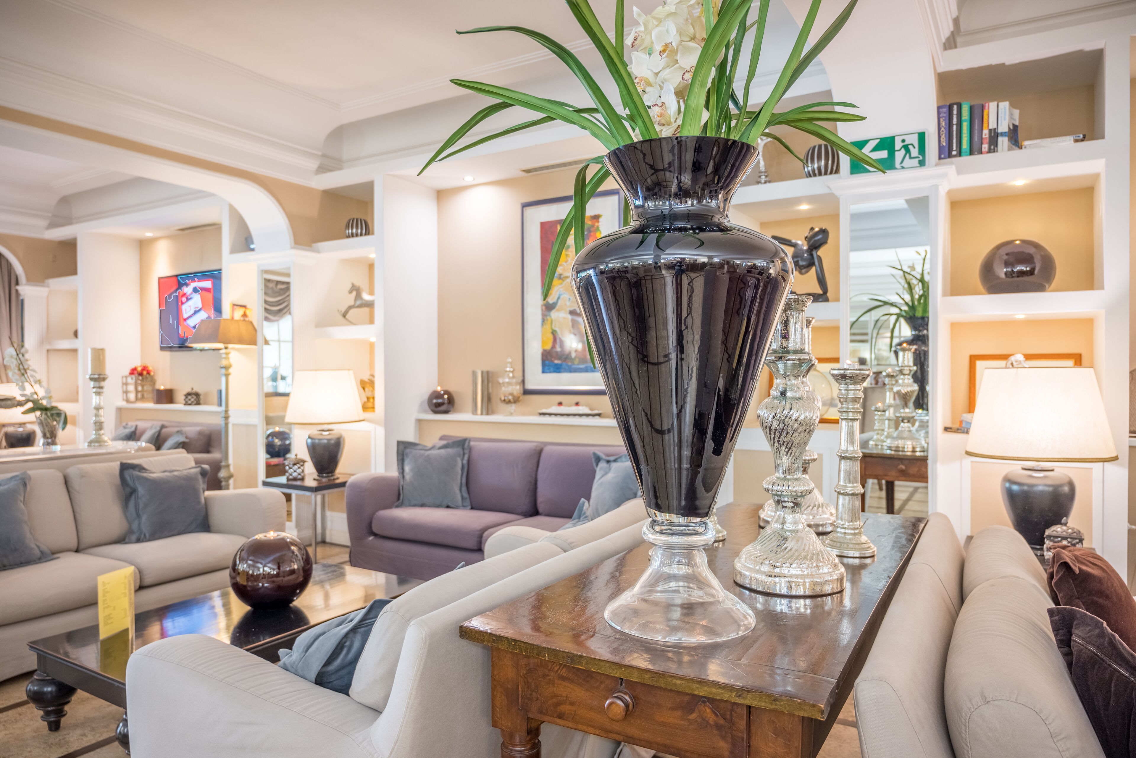 A well-lit living room with a large decorative vase, sofas, and a coffee table.