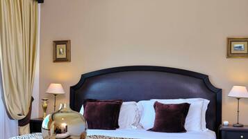 A hotel room with a large bed, two bedside lamps, a decorative vase, and a zebra-patterned throw.