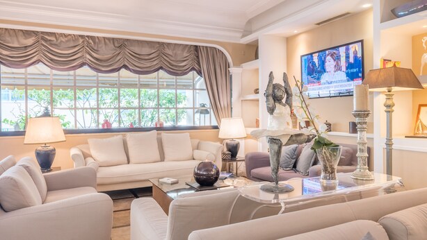 A modern living room with a beige sofa, a coffee table, and decorative items.
