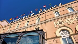 Exterior del Excelsior Palace con banderas y detalles arquitectónicos.
