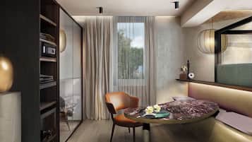 A modern living room with a curved sofa, a glass coffee table, and a wooden bookshelf.