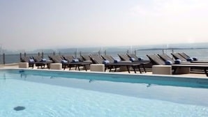 Una piscina amb gandules ia una vista del mar.