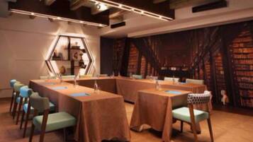 A conference room with a long table and chairs, a hexagonal display, and bookshelves in the background.