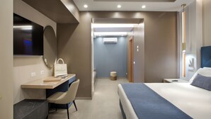 A modern hotel room with a bed, desk, chair, and a television. - Montespina Park Hotel (Naples)