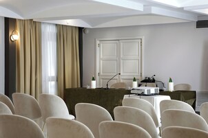 Una sala conferenze con un tavolo, sedie, un proiettore e microfoni.