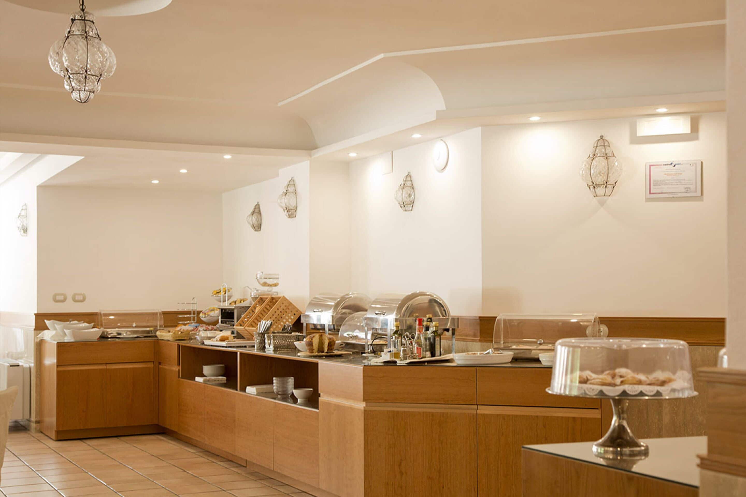 A modern breakfast bar with a variety of food items and a decorative glass lamp.