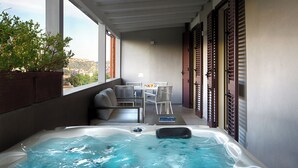 A balcony with a hot tub, seating area, and a table with chairs. - Montespina Park Hotel (Naples)